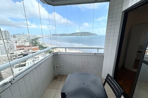 Un balcón con vista al océano y una isla distante.