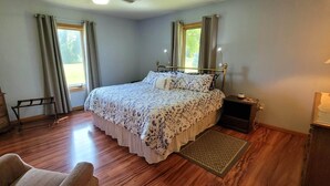 A bedroom with a bed, dresser, nightstand, lamp, and a television. - Luxury Home with Indoor Pool, 3-bedroom house in delightful Milford MI (Milford)