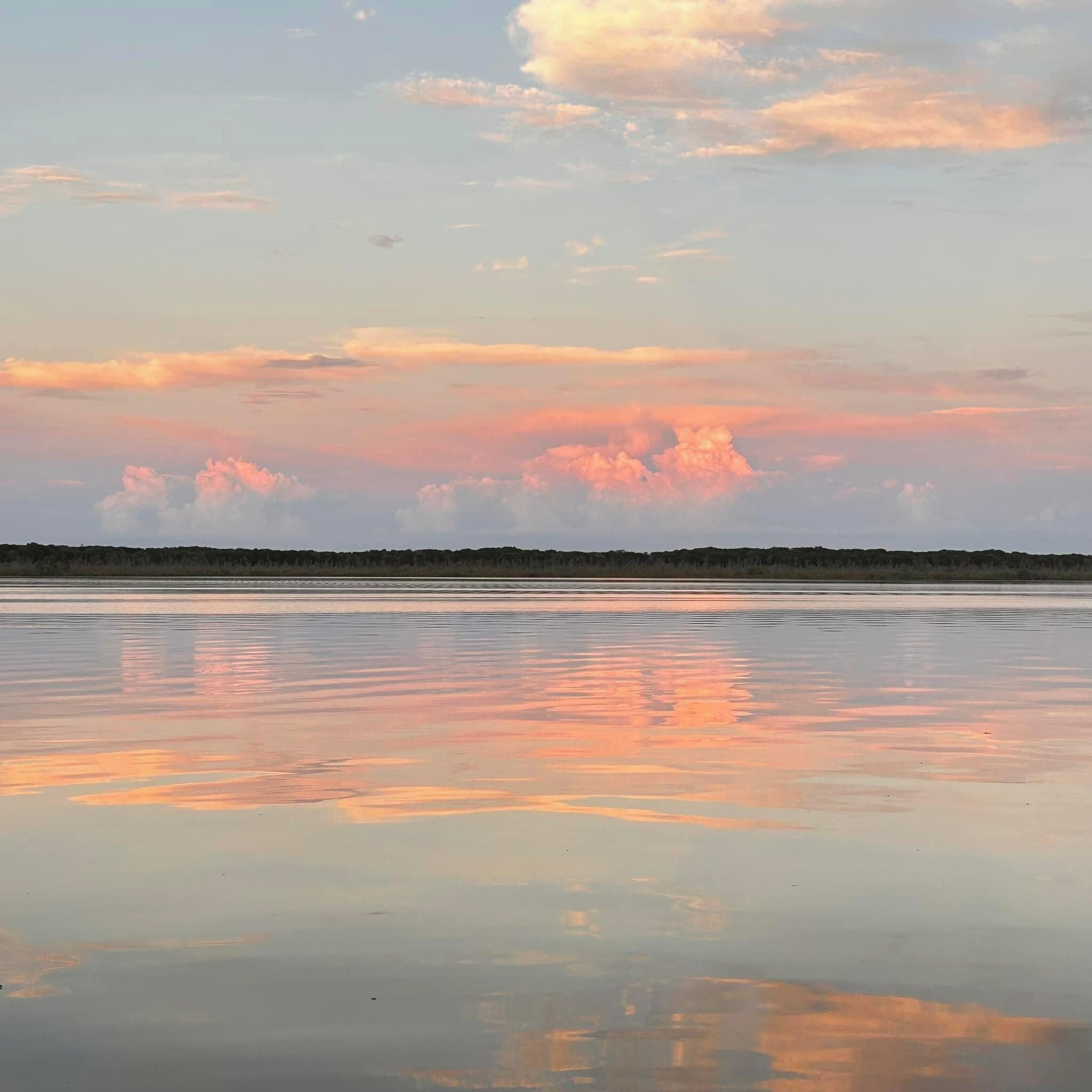 A calm body of water reflecting the sky.