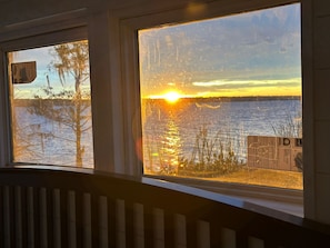 A window with a view of a sunset over water, a tree, and a fence. - Romantic retreat/best fishing in central Fl. Close to springs and the villages (Lake Panasoffkee)