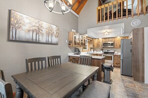 The dining and kitchen areas offer a warm and inviting space, featuring a comfortable dining setup and a well-equipped kitchen perfect for preparing meals and gathering together. - Stone Throw- Near Creek- Unique- Great Location (Hill City)