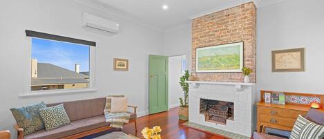 A living room with a fireplace, a sofa, a coffee table, and a television.