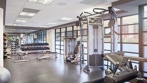 Una palestra con attrezzature per esercizi, manubri e un'ampia finestra.