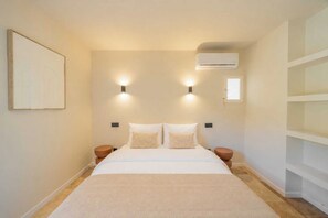 A bedroom with a bed, two wall-mounted lights, an air conditioner, and a small window. - Modern House a/c Pool 1br/ 2P - Font Mourier (Cogolin)
