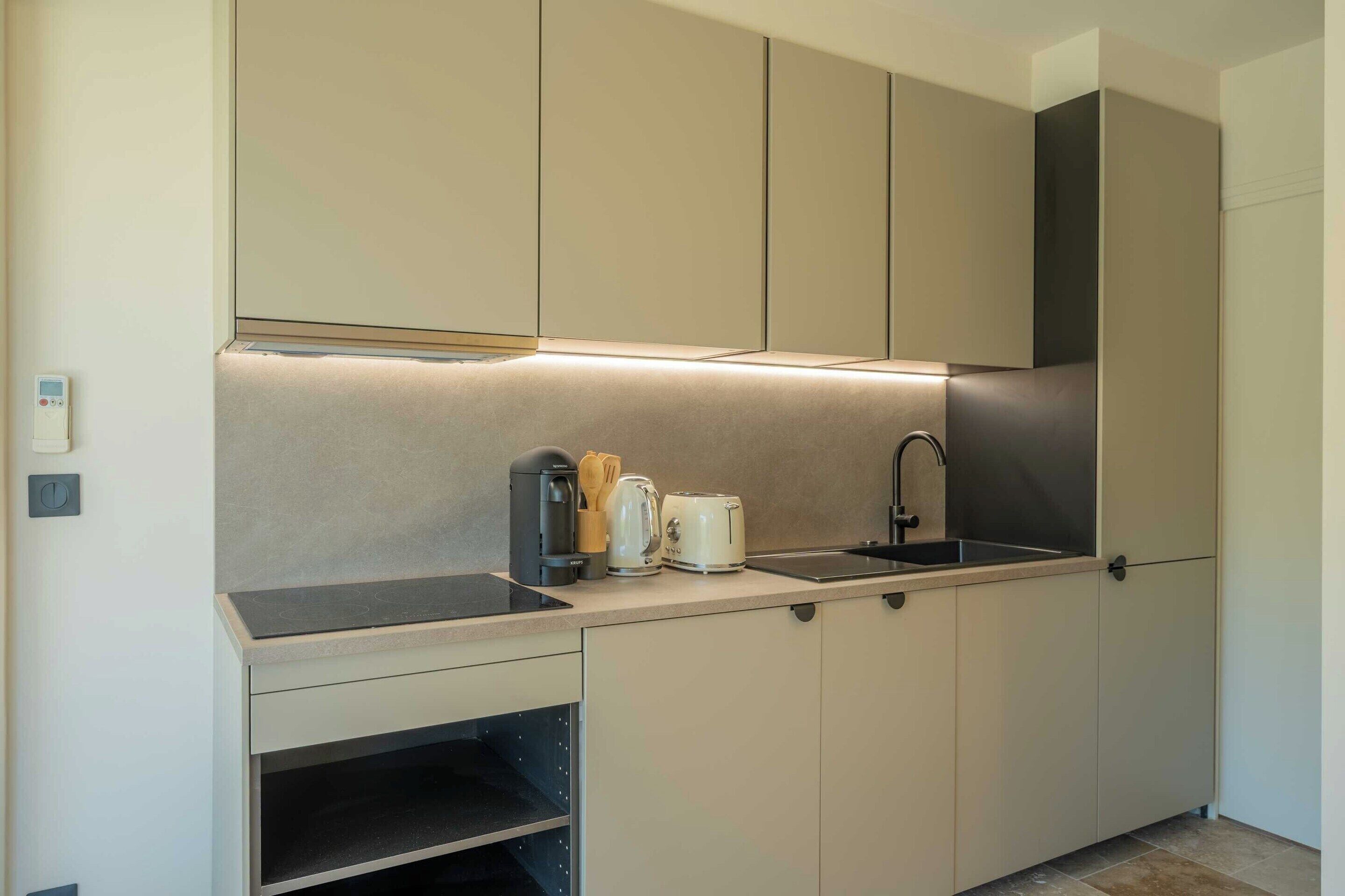 Una cucina moderna con piano cottura integrato, lavello e macchina da caffè.