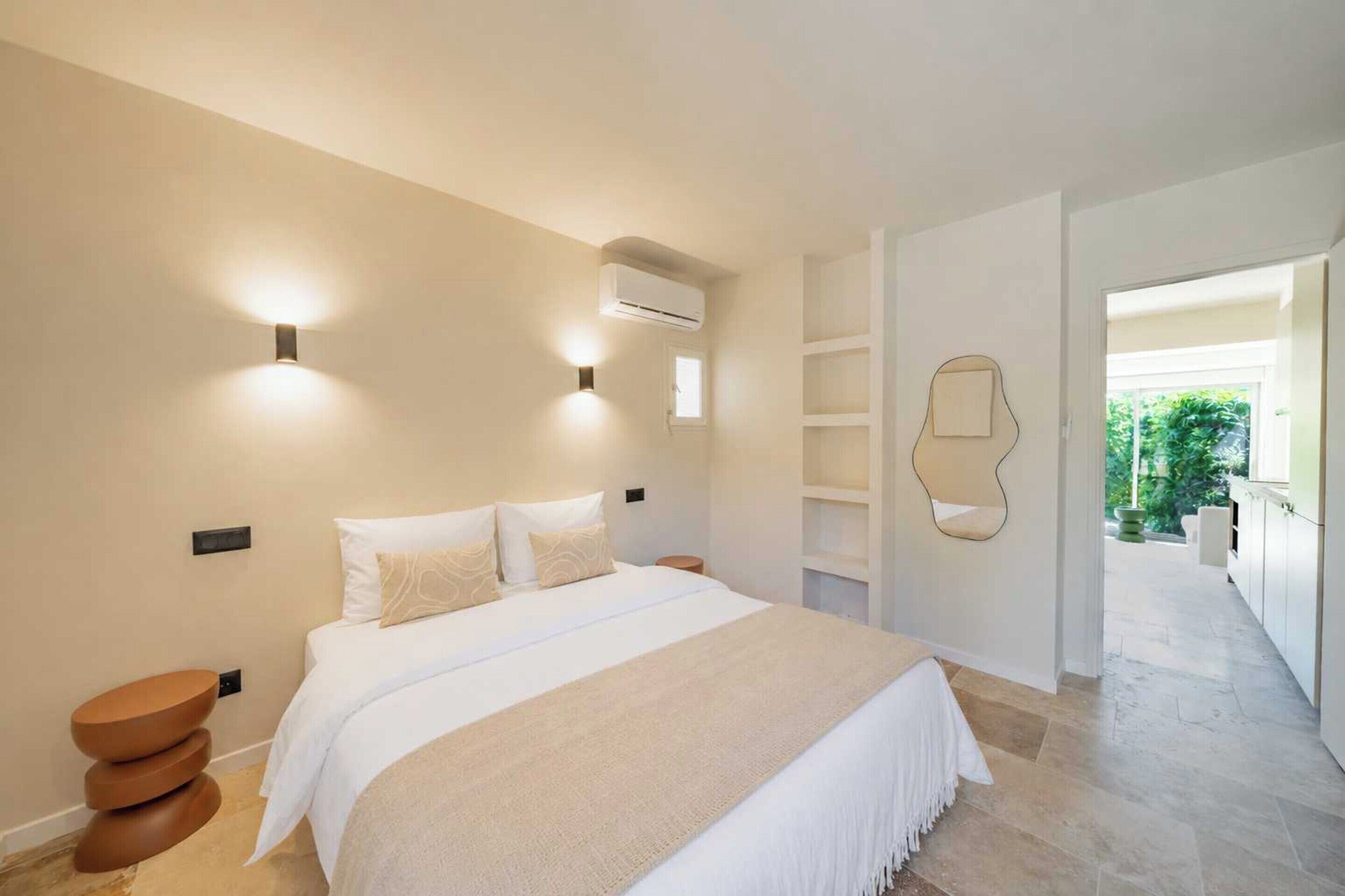 A modern bedroom with a large bed, bedside tables, and a built-in wardrobe.