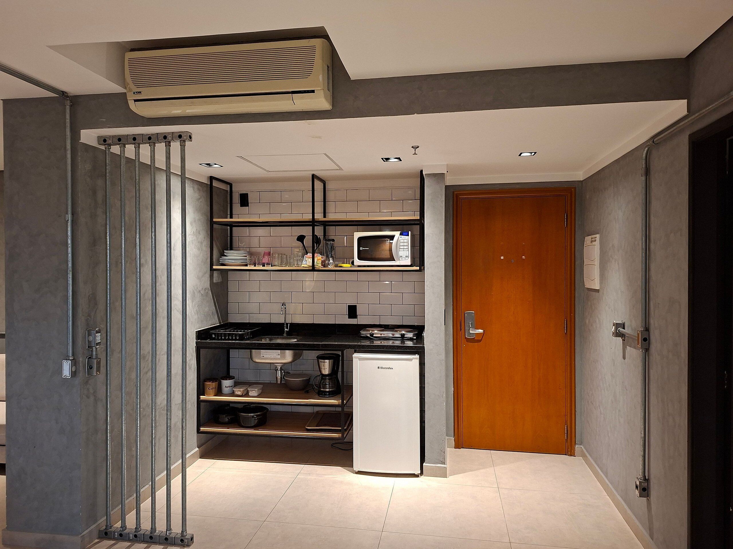 A compact kitchen with a microwave, stove, and refrigerator.
