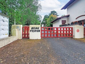 Ein begrenzter Zugangsbereich mit einem Schild mit der Aufschrift 'BEAU SEJOUR' und einem Briefkasten.