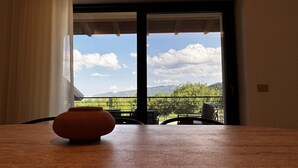 Ein Zimmer mit Blick auf Berge und Bäume durch ein großes Fenster.