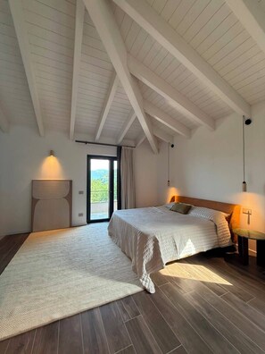 A bedroom with a large bed, a smaller bed, a window with curtains, and a view of greenery outside. - Casa Magnolia: Spacious Boutique Mountain Home - 4 Bathrooms - Panoramic Views (Sestola)