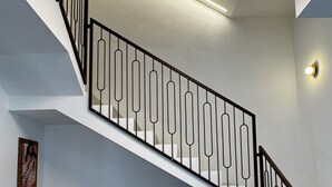 Eine moderne Treppe mit einem außergewöhnlichen Geländer und ein runder Tisch mit einer Schale im Vordergrund.