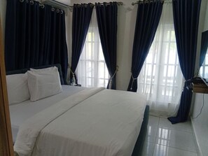 A hotel room with a bed, curtains, and a window. - Devon's Villa and Apartments Apo (Abuja)