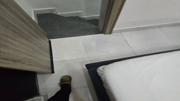 Een slaapkamer met een bed, een raam en een deur.