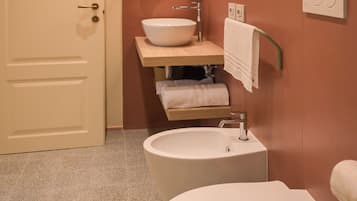 Een badkamer met toilet, wastafel en spiegel.