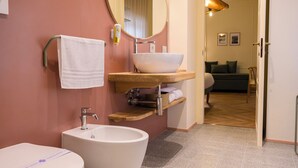 Une salle de bain moderne avec une baignoire sur pieds, un lavabo blanc et une coiffeuse avec un miroir.