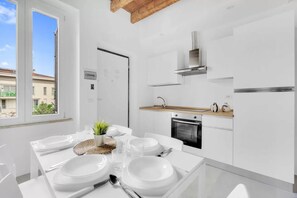 Eine moderne Küche mit weißen Schränken, einer Holz Arbeitsplatte und einem eingebauten Backofen.