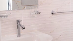 A bathroom with a white sink, a mirror, and a towel rack. - Yireh Hotel Grand Suites (San Juan de la Maguana)
