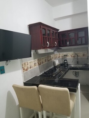 A kitchen with a gas stove, a sink, and wooden cabinets.