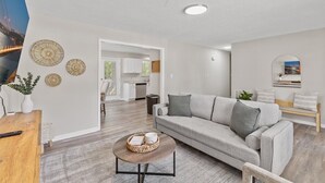 Un salon moderne avec un canapé, une table basse et des œuvres d’art décoratives au mur.