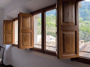 A room with a large window, wooden shutters, and a view of a mountainous landscape. - Bright Village apartment, wrap around mountain views in Fornalutx.HighspeedWIFI (fornalutx)