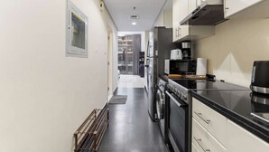 A modern kitchen with stainless steel appliances, a coffee maker, and a toaster. - Stylish Studio in DAMAC Hills with Pool, Gym & Balcony (Damac hills)