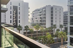 A modern building with a prominent sign reading 'DAMAC HILLS'. - Stylish Studio in DAMAC Hills with Pool, Gym & Balcony (Damac hills)