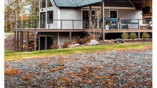 Une maison à deux étages, dotée d’un toit en pente, d’un porche couvert et d’une allée gravillonnée.
