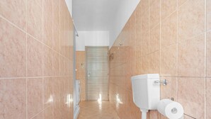 A narrow hallway with a toilet, a paper towel dispenser, and a door at the end. - ZAN20: A Comfortable and Bright Apartment in Milan (Milano)