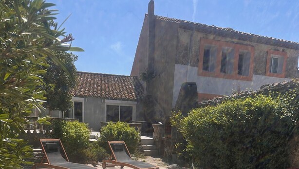 A swimming pool with lounge chairs, a tiled patio, and a building with a tiled roof. - Village house nestled among ponds, scrubland, and a wild beach (La Palme)
