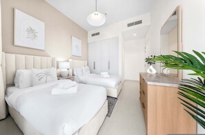 A hotel room with two beds, a wooden dresser, a large mirror, and artwork on the walls. - Free Housekeeping Visits During Your Stay - Stayshort - Exceptional 3 Bedroom Villa in Emaar South That Sleeps 8 (Dubai)