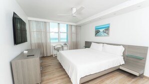 A modern hotel room with a bed, desk, chair, and a view of the ocean. - Casa Jenny 2BR2BA 2026 Remodeled (Carolina)