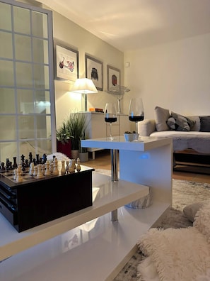 Un salon moderne avec un jeu d’échecs, un canapé, une table basse et une lampe.