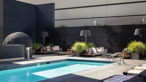 A rooftop pool area with lounge chairs, potted plants, and a modern architectural design. - Stylish 1BR Retreat with Modern Comforts at Nema (San Francisco)