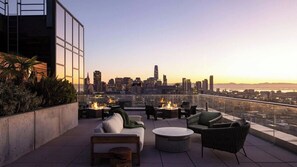 Une terrasse sur le toit avec des sièges extérieurs, une vue panoramique sur la ville et un foyer.