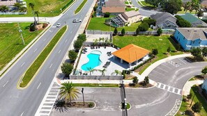 An aerial view of a residential area with a swimming pool, a road, and houses. - 5BR Private Pool Home Near Disney (Kissimmee)