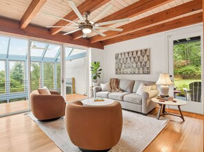A spacious living room with a high ceiling, a ceiling fan, a large window, and a view of the outdoors. - Luxury Blue Ridge Retreat - Hot Tub - 15 Min to Early Mountain Vineyard (Stanardsville)