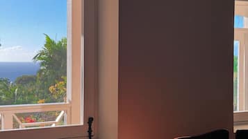 A room with a large window, a wooden table, and two chairs.
