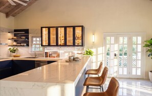 Una cocina moderna con encimera de mármol, armarios empotrados y un amplio ventanal.