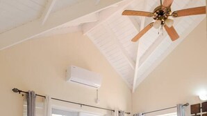 A room with a bed, a ceiling fan, an air conditioning unit, and a window with curtains. - Cap Estate Private Caribbean Villa with Ocean Views (Gros Islet)