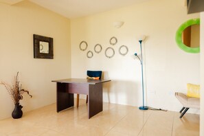 A room with a desk, chair, floor lamp, decorative wall rings, and a mirror. - Apartment in Cap Estate, Gros Islet (Gros Islet)