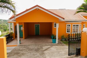 A two-story building with a red roof, a green door, and a black gate. - Apartment in Cap Estate, Gros Islet (Gros Islet)