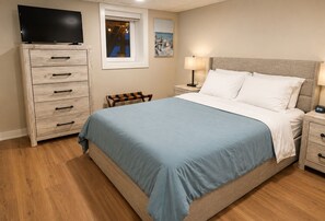 A bedroom with a bed, a TV, a dresser, a chair, a nightstand, a lamp, and a painting. - Private Pool Retreat, Fire Pit, Game Room (Oak Grove)
