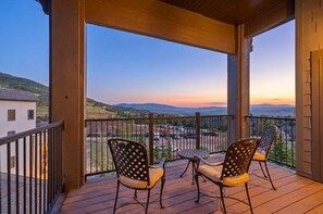 A balcony with two chairs and a table, overlooking a parking area and distant hills. - New Listing Canyons Resort, Silverado, Pool, Golf! (Park City)