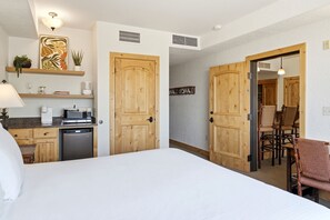 A hotel room with a bed, a kitchenette, wooden doors, and a dining area. - New Listing Canyons Resort, Silverado, Pool, Golf! (Park City)