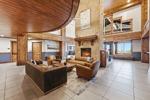 A spacious living room with a fireplace, leather sofas, and a high ceiling with wooden beams. - New Listing Canyons Resort, Silverado, Pool, Golf! (Park City)