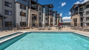 A swimming pool with lounge chairs and a building with balconies. - New Listing Canyons Resort, Silverado, Pool, Golf! (Park City)