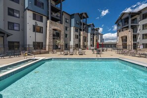 A swimming pool with lounge chairs and a building with balconies. - New Listing Canyons Resort, Silverado, Pool, Golf! (Park City)