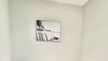 Quarto com uma cama, um quadro na parede e uma luminária no teto.