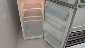 Un frigorifero compatto con diversi scomparti, tra cui un congelatore e un vano principale.