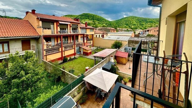 A residential area with multiple buildings, a courtyard, and a view of green hills. - A Cozy Wooden Duplex casa Ski Retreat| 2BR,2BA in a Peaceful Town near Camprodón (Sant Pau de Segúries)